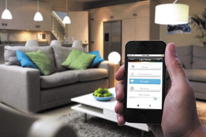 Un usuario utiliza su telèfono inteligente en una casa